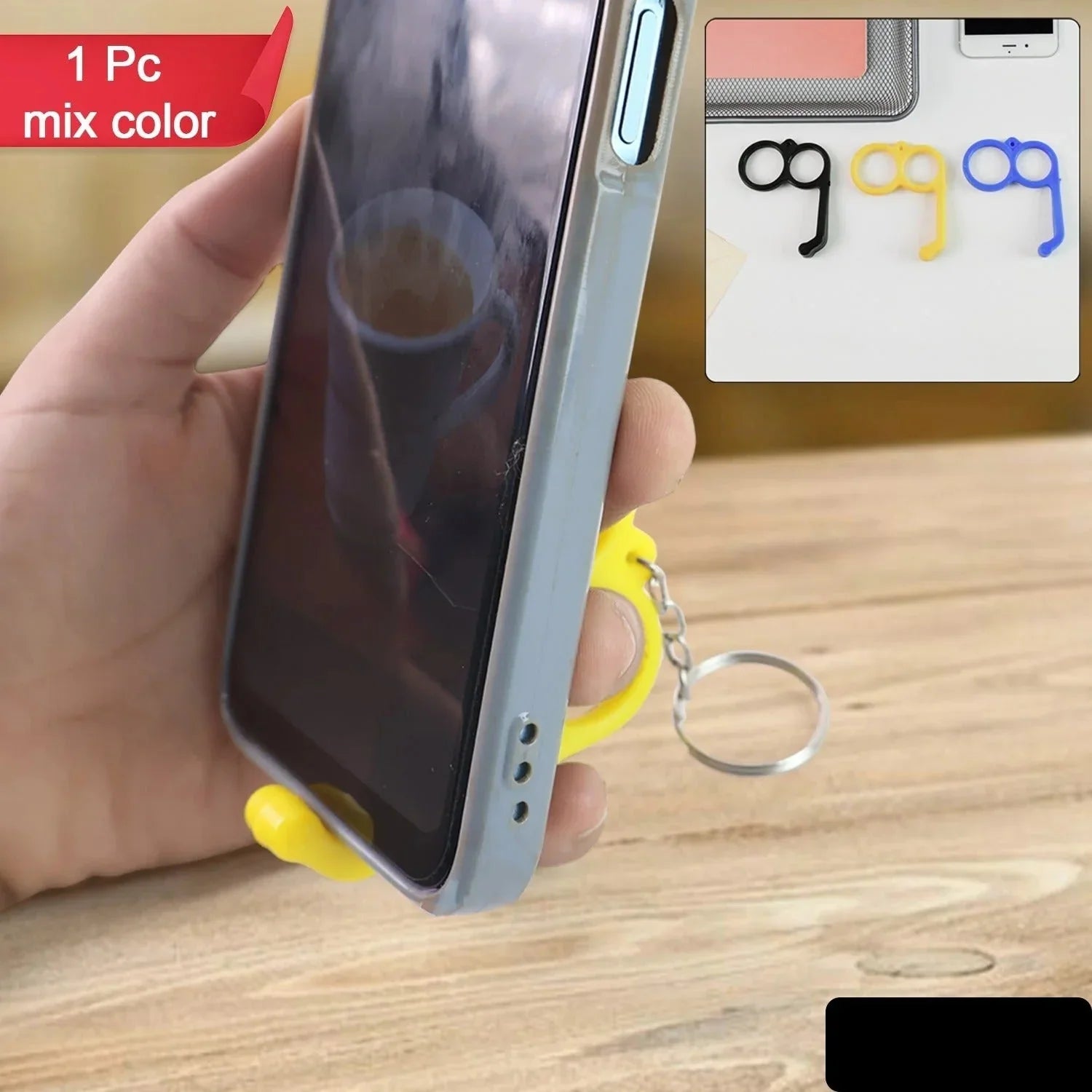 Hand holding a phone with a yellow stand and keychain, with earphone illustrations inset.